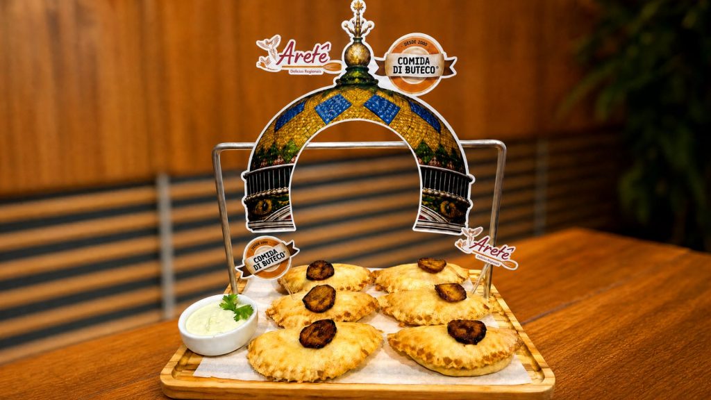 Petisco campeão do Comida di Buteco 2026 em Manaus, Empanada à Cabocla com Molho Floresta do Aretê Delícias Regionais, servido em bandeja com identidade visual do concurso.